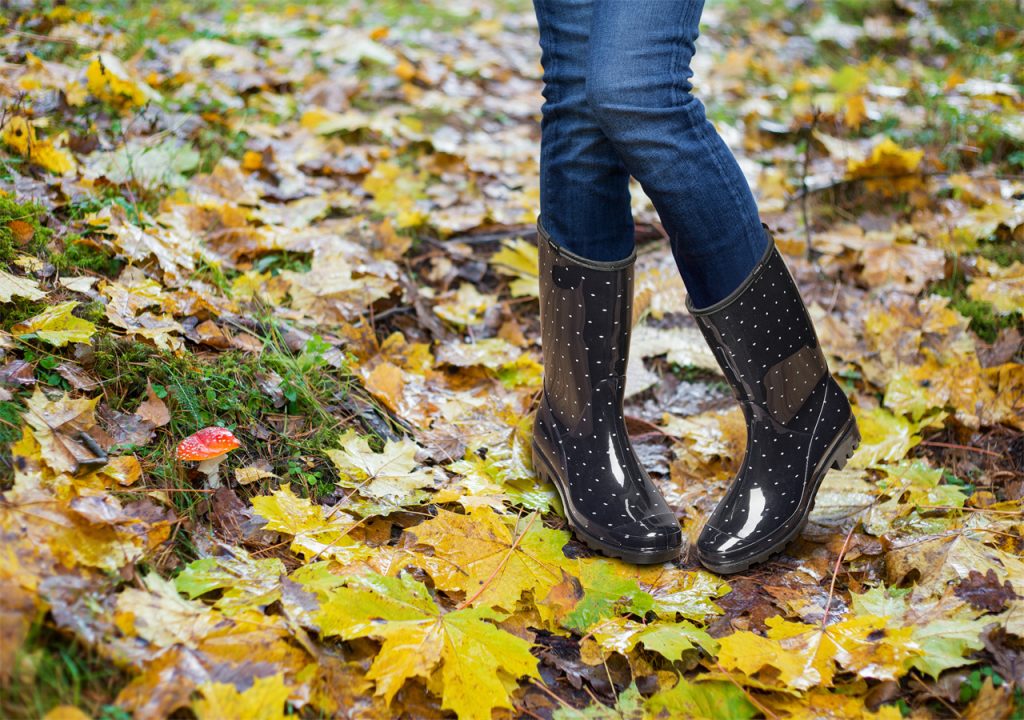 A person who is wearing a pair of PVC rain boots dances in the mud