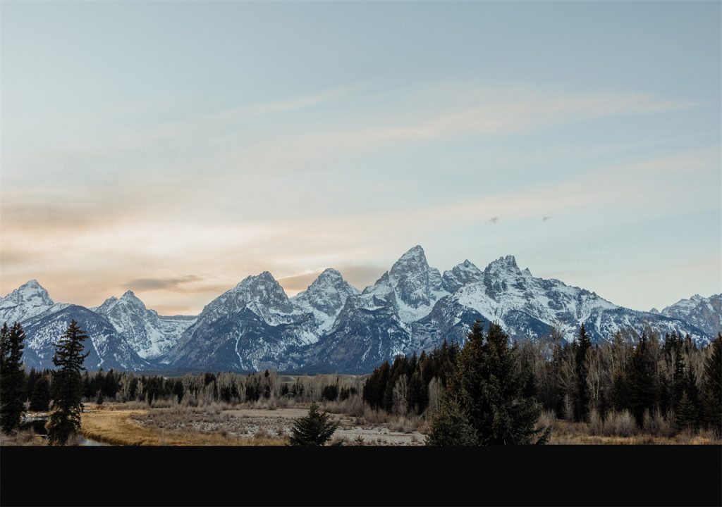 On a clear winter day, mountains and forests shine in the sunlight.