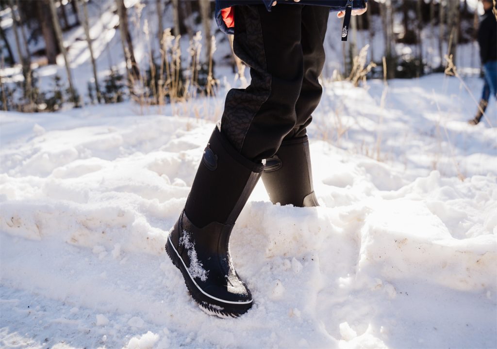 A man is playing happily with the snow wearing HISEA snow boots.