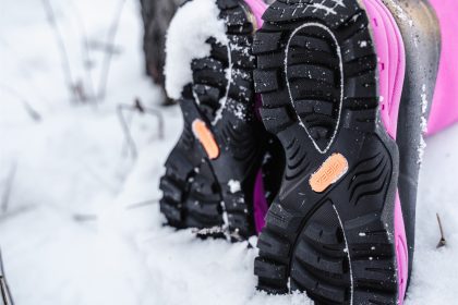 A woman is walking in the snow wearing HISEA snow boots.