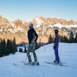 Two people stopped skiing and were resting, looking into the distance.