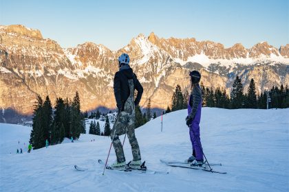 Two people stopped skiing and were resting, looking into the distance.