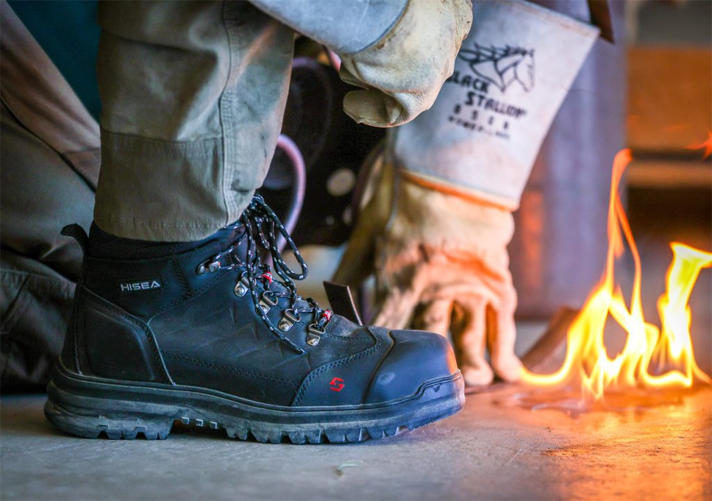 A welder is working in the factory, with flame crawling on the ground.