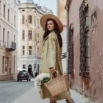 An elegant woman is carrying a handbag with some beautiful flowers inside and is wearing HISEA cowboy boots.